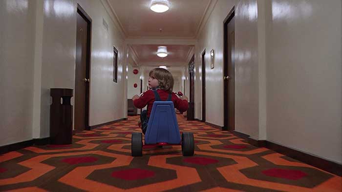 映画『シャイニング（1980）』より あまりにも有名なワンシーン。 ローアングルから手持ち撮影で走る三輪車を追い続けることで、『ホテル』の視点であることを観ているものに感じさせている。